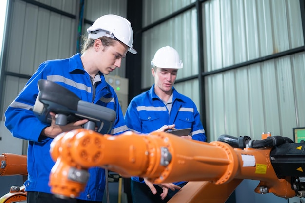 Engineer and technician working with robot arm in factory Industry and engineering concept