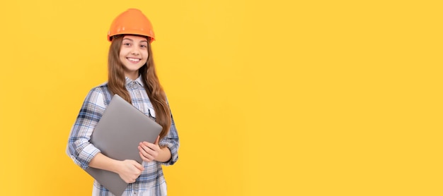 Photo engineer teenager girl happy teen girl in helmet and checkered shirt holding computer modern life child in hard hat horizontal poster design banner header copy space