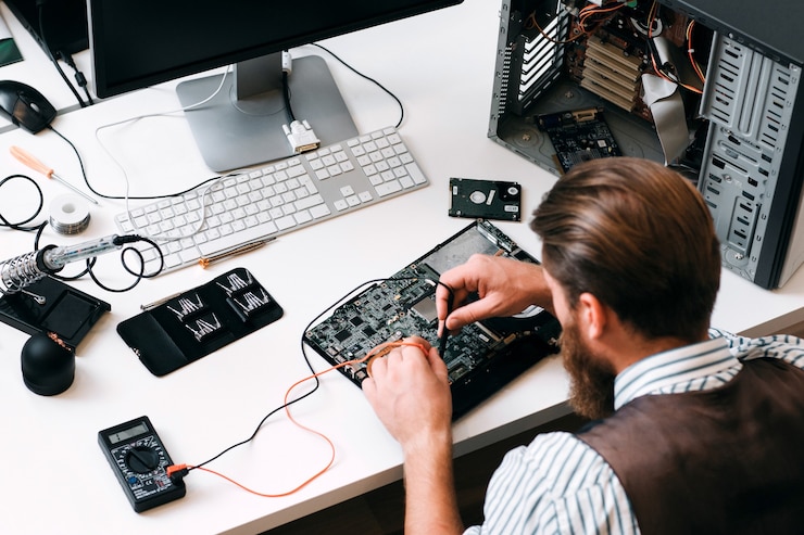 Photo engineer testing computer circuit with multitester. top view on unrecognizable repairman with tester cables in hands, examing electronic component near disassembled cpu