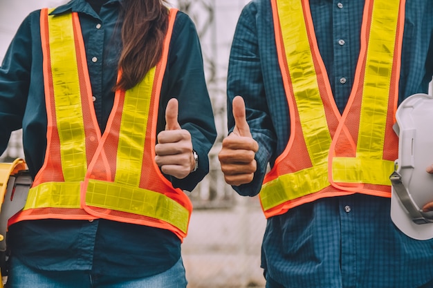 Engineer two people holding hard hat wear safety suit