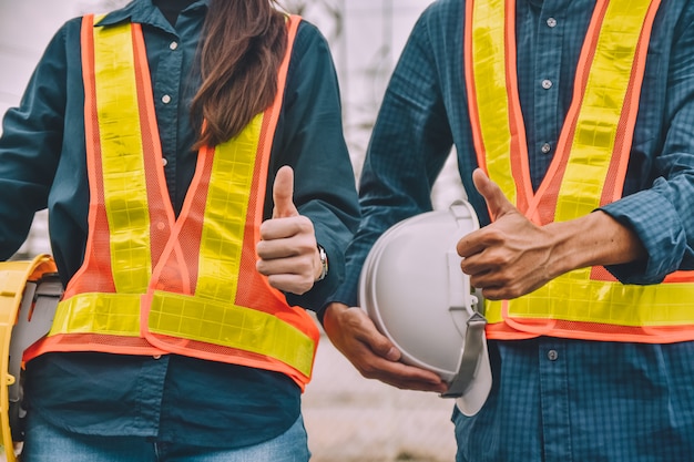 Engineer two people holding hard hat wear safety suit