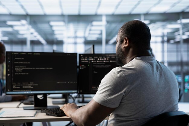 engineer typing code on pc to mend data center racks