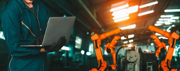 写真 エンジニアは高度なロボットソフトウェアを使用して、工場で産業用ロボットアームを制御します
