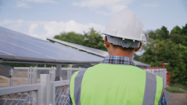 Engineer walk around solar cells station for checking system\
and maintenance solar panel, green energy and sustainable\
environment concept.