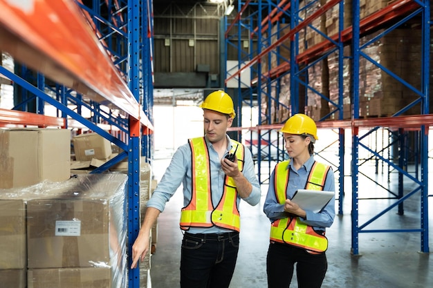 Engineer wearing safety vest controlling machine working talking with assistant engineer worker checking safety first for labour workers Safety officer check box in warehouse