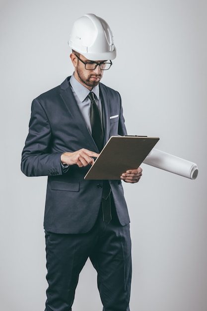 Engineer with drafts examining clipboard