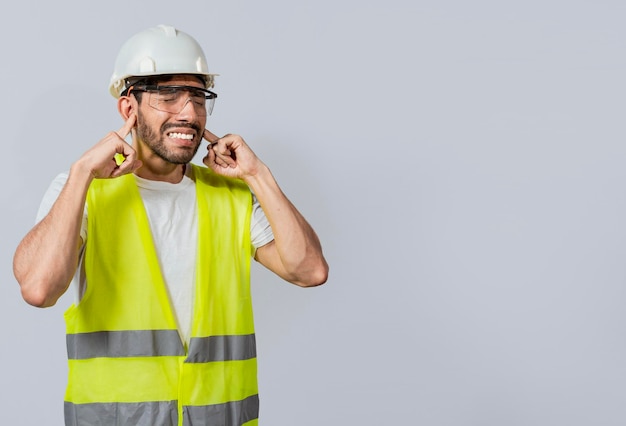 Engineer with ear pain isolated Young engineer covering his ears isolated Builder man with ear pain Concept of engineer covering his ears with pain expression