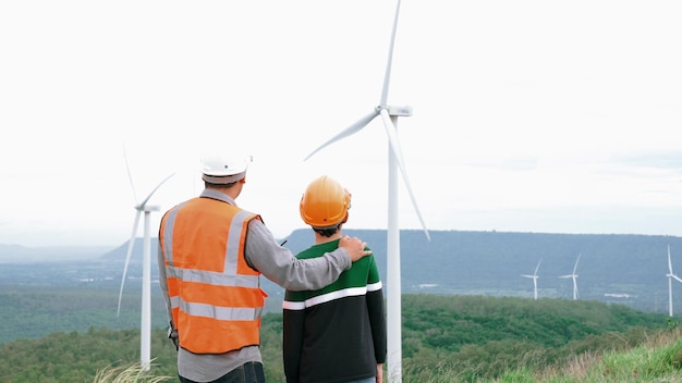 Photo engineer with his son on a wind farm atop a hill or mountain in the rural progressive ideal for the future production of renewable sustainable energy energy generation from wind turbine