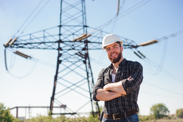 Ingegnere con elmetto bianco sotto le linee elettriche. ingegnere di lavoro