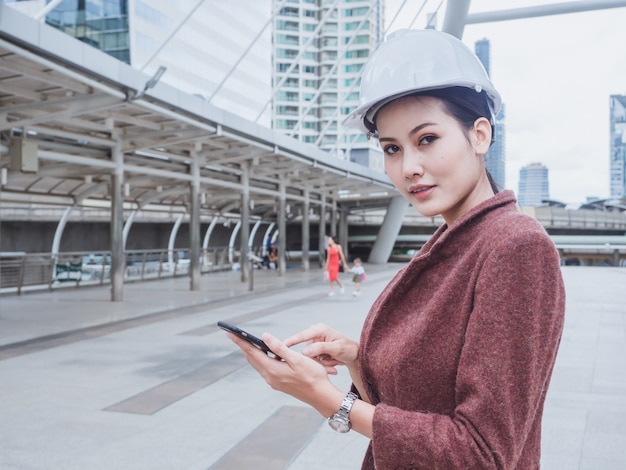 写真 エンジニアの女性は都市で電話を使用します