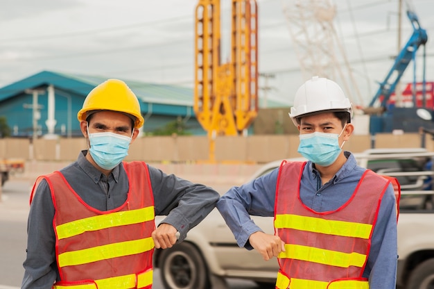 Engineer Worker Working teamwork on site construction , Man wear mask covid19