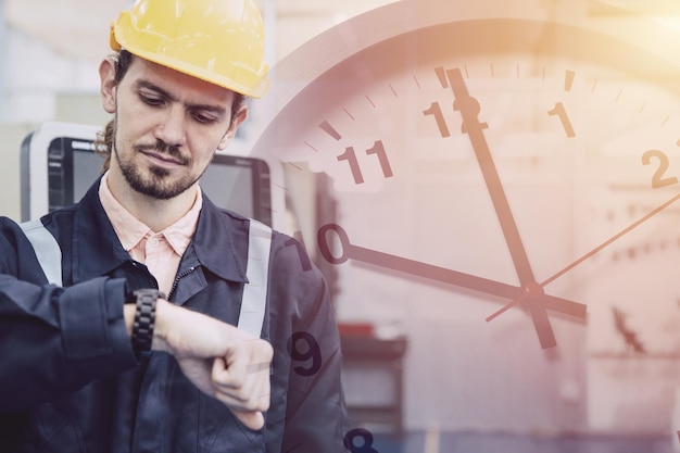 Il lavoratore ingegnere si preoccupa guardando il quadrante dell'orologio del tempo di sovrapposizione dell'orologio concetto di orario di lavoro in fabbrica industriale