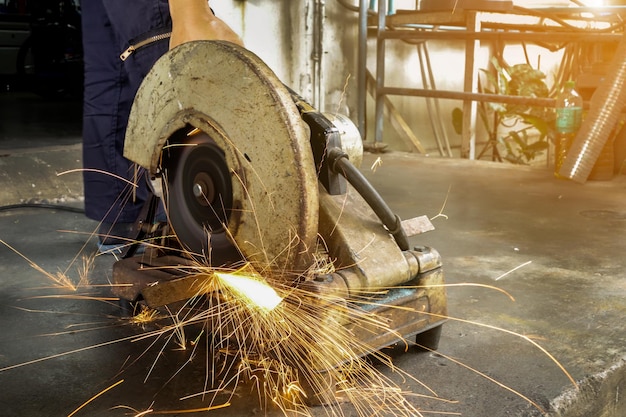 Engineer working on cutting a metal and steel with compound\
mitre saw with sharp flakes