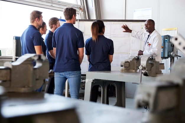 Engineering apprentices watching presentation at whiteboard