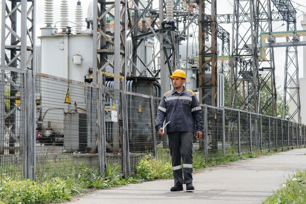 An engineering employee makes a tour and inspection of a modern electrical substation. Energy. Industry.