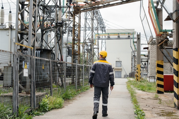 An engineering employee makes a tour and inspection of a modern electrical substation.