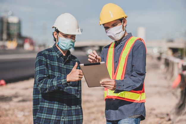 Engineering holding tablet work on road construction focus on tablet