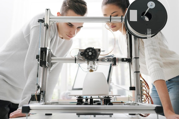 Engineering students using a 3D printer in the lab