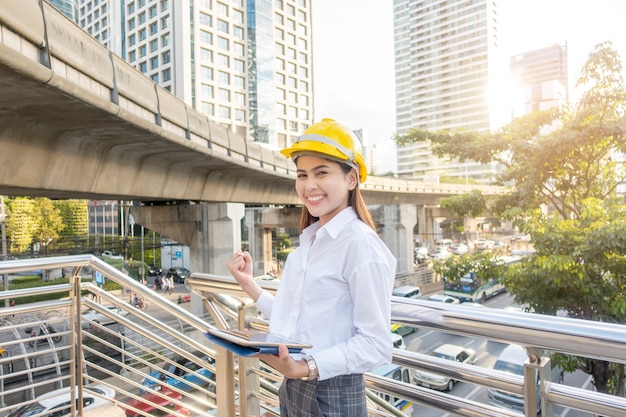 エンジニアリングの女性は屋外の街で働いています。