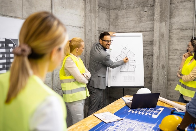 Foto ingegneri e architetti che si incontrano in cantiere per analizzare la fase successiva della costruzione