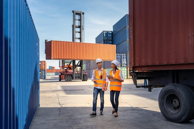 Engineers are overseeing the transportation of cargo with containers inside the warehouse