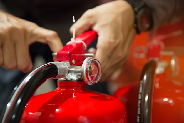 Engineers are pull the safety pin of fire extinguishers.