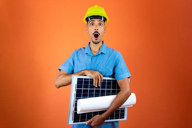 엔지니어의 날 안전 헬멧과 파란색 셔츠에 흑인 남자 절연 태양광 태양 전지 패널을 들고 엔지니어
