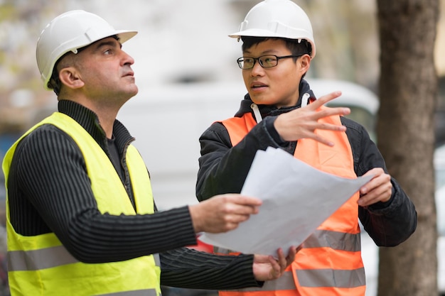 Photo engineers discussing while standing at construction site