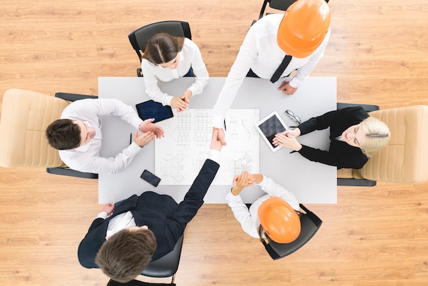 The engineers handshake and applause near the drawing. view from above