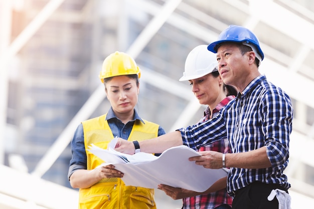 Engineers man and woman working on plan building construction in city