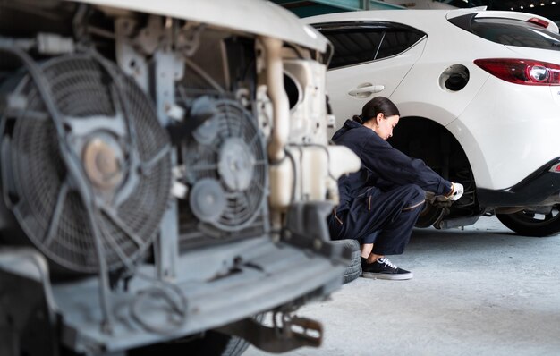 Foto ingegneri e meccanici utilizzano la tecnologia per rilevare i guasti nel funzionamento del motore in garage