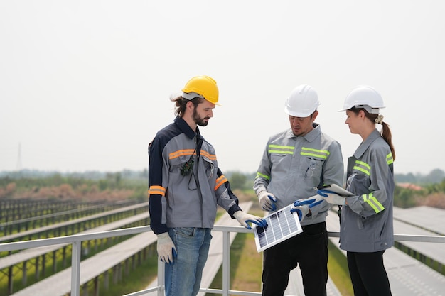 Riunione degli ingegneri per controllare il pannello solare nel parco solare sul tetto con un sistema di accumulo di energia gestito da super energy corporation specialisti riuniti per test all'aperto modulo celle fotovoltaiche