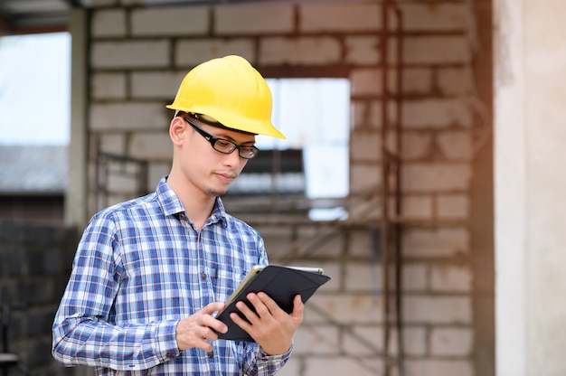 Gli ingegneri usano un tablet per controllare la costruzione. ingegnere con gli occhiali guardando il tablet.