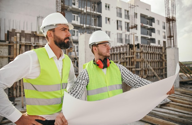 Engineers with draft inspecting construction site