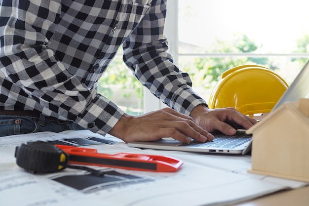 Engineers work with laptops and blueprints. Calculate and check the construction project 