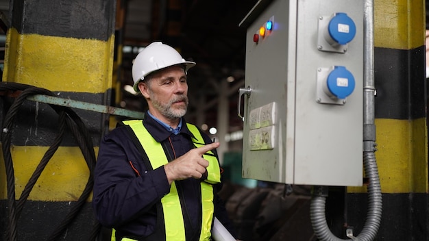 Engineers working at factory in powerplant and maintenance\
check on electric control box in factory