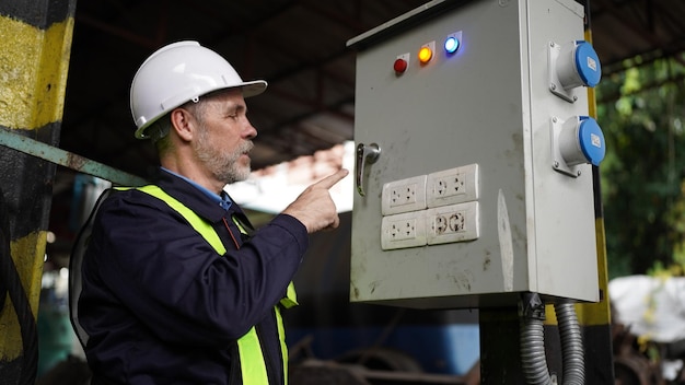 Engineers working at factory in powerplant and maintenance\
check on electric control box in factory