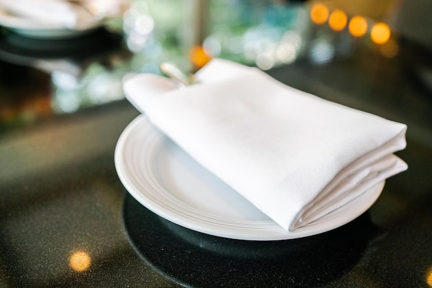 English afternoon tea table with white napkin cutlery and plate on the black granite tabletop