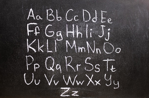 写真 黒板に粉筆で刻まれた英語のアルファベットの文字 英語のアルファベットを学ぶ