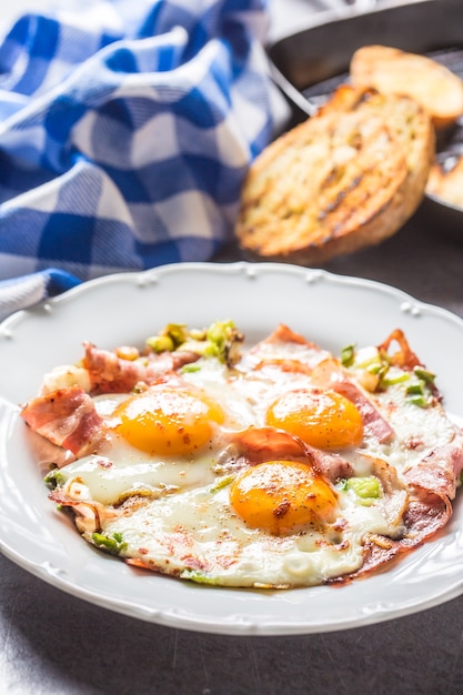 Photo english breakfast fried bacon ham and eggson white plate.