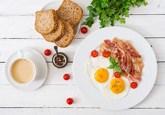 Английский завтрак - жареное яйцо, помидоры и бекон.