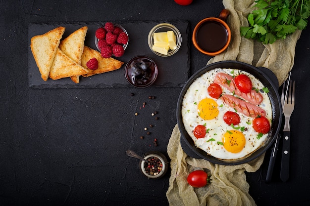 English breakfast - fried egg,  tomatoes and sausage. Top view. Flat lay