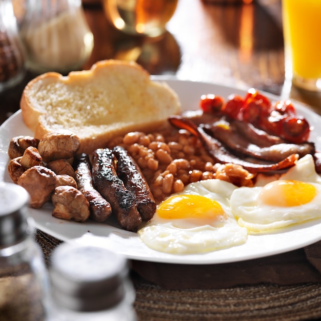 Foto prima colazione inglese su un piatto bianco