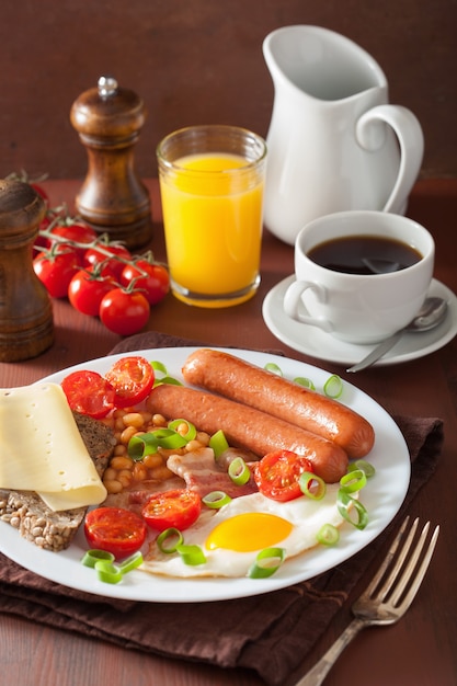 English breakfast with fried egg sausages bacon tomatoes beans