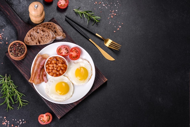 English breakfast with fried eggs bacon beans tomatoes spices and herbs