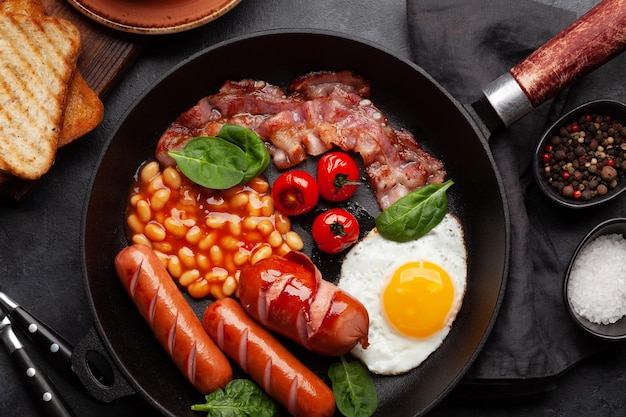 English breakfast with fried eggs beans bacon and sausages Top view flat lay