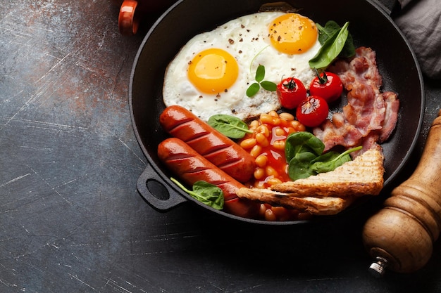 Английский завтрак с жареными яйцами, фасолью, беконом и сосисками