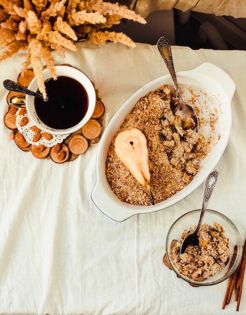 English crumble with apples close-up in white linen tablecloth. Horizontal rustic style. 