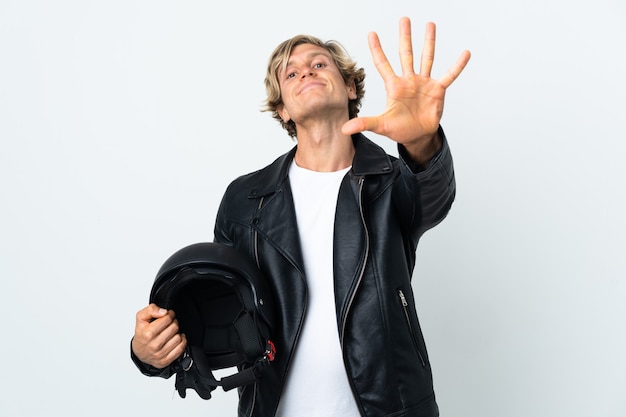 English man holding a motorcycle helmet counting five with fingers