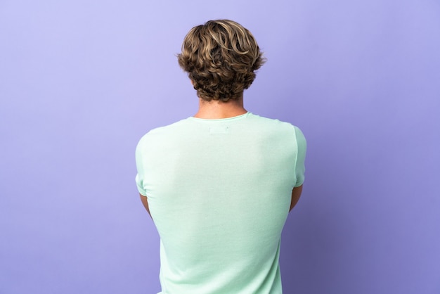 Foto uomo inglese su sfondo viola isolato in posizione posteriore